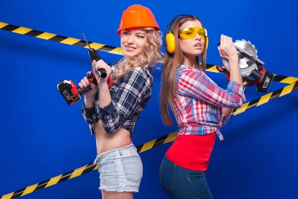 ヘルメットと青色の背景に作図ツールとゴーグルの女の子ビルダー — ストック写真