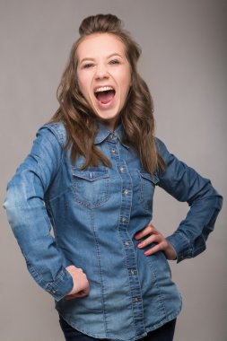 Portre enerjik eğlenceli kız öğrenci gri bir arka plan üzerinde bir