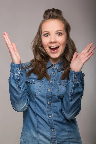 Porträt einer energiegeladenen Studentin auf grauem Hintergrund in einem — Stockfoto