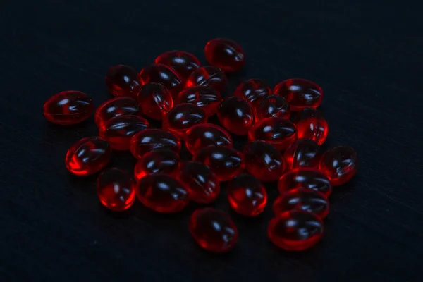 Tablets red capsules in bulk, with a depth of field picture — Stock Photo, Image