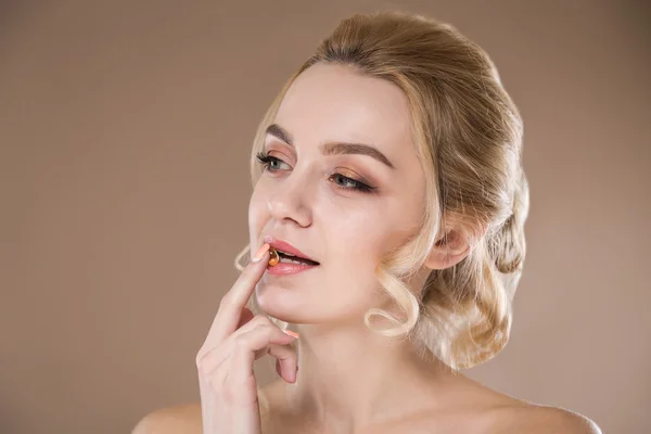 Ragazza con una pillola gialla in mano — Foto Stock