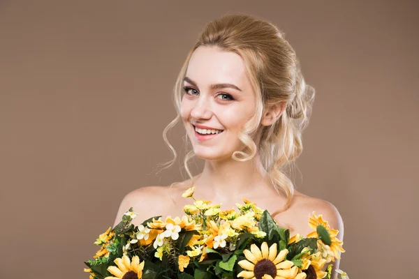 Blondin med blommor i händerna — Stockfoto