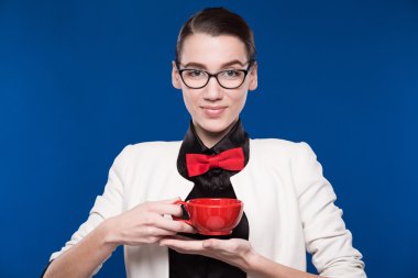 onun elinde bir fincan ile gözlüklü esmer