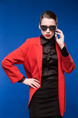 Güneş gözlüğü ve elinde bir telefon ile genç bir kız portresi