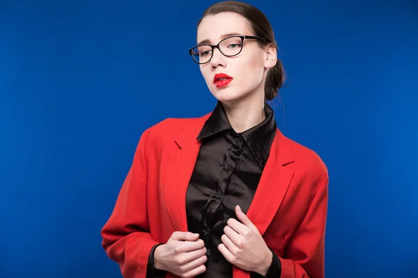 Retrato de una chica con gafas y una chaqueta roja — Foto de Stock