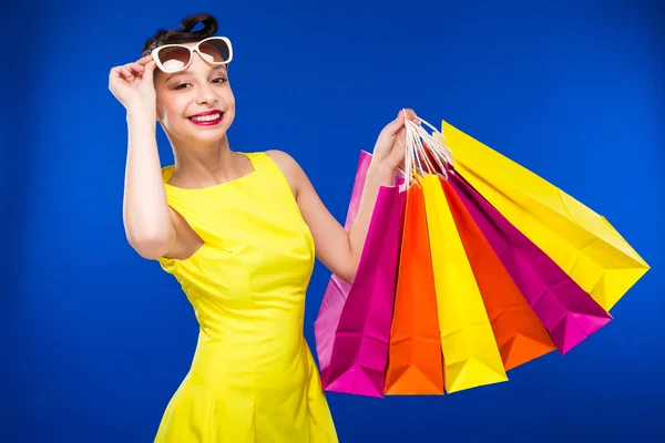 Chica en un vestido y gafas con paquetes — Foto de Stock