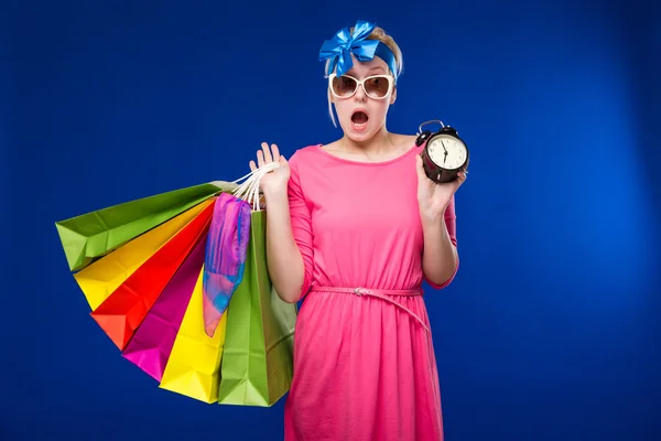 Mädchen mit Taschen und Wecker in der Hand — Stockfoto