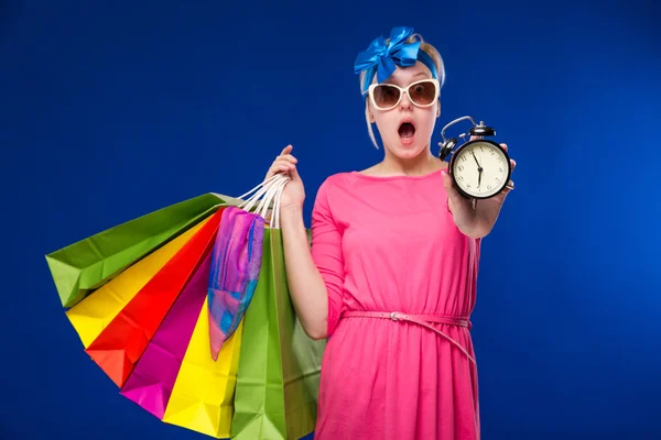 Mädchen mit Taschen und Wecker in der Hand — Stockfoto