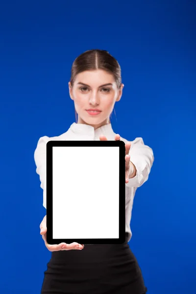 Mujer con una tableta enfocada en un fondo azul — Foto de Stock