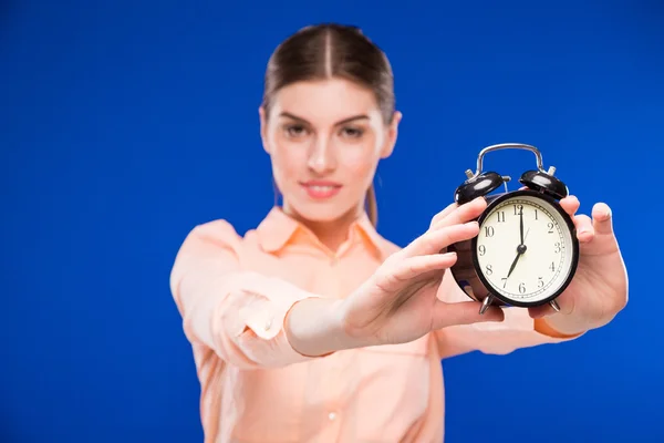 Young girl with an alarm clock in focus Stock Picture