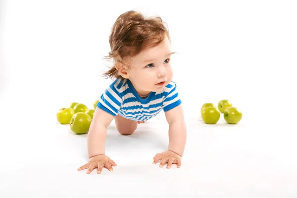 Little boy on the floor with green apples — Stock Photo, Image