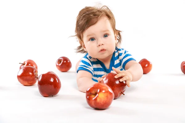 A little boy with a pile of apples — Stock Photo, Image