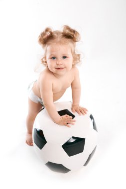 küçük çocuk bir futbol topuyla oynuyor