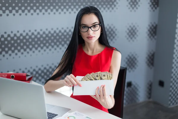 Молода бізнес-леді тримає гроші в конверті — стокове фото