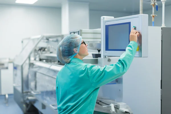 Operator in de farmaceutische fabriek in de buurt van de apparatuur — Stockfoto