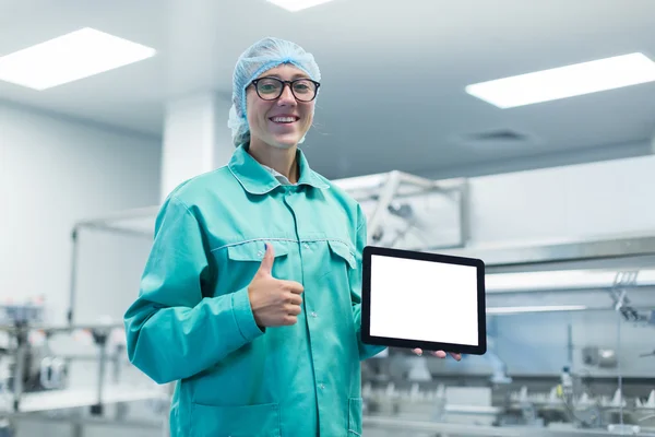 Trabajador de la fábrica farmacéutica con una tableta en sus manos muestra Equipo —  Fotos de Stock