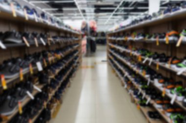 many shoes on the shelves are in the shoe store, blurred and defocused