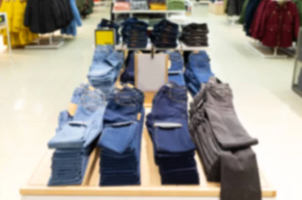 Clothing store with a large assortment of pants and jeans hanging on hanger, blurred and defocused — Foto Stock