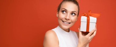 Güzel, mutlu, genç, sarışın bir kadın. Renkli arka plan duvarından izole edilmiş. Şık, sıradan giysiler içinde.