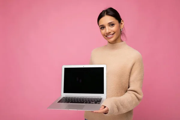 Foto de bela jovem segurando laptop computador olhando para câmera isolada sobre fundo colorido — Fotografia de Stock