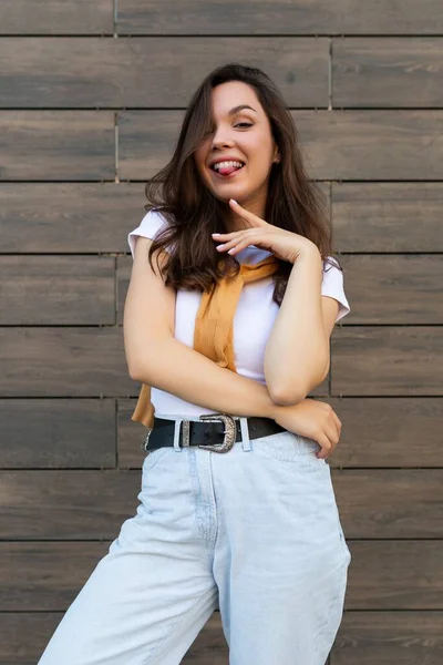 Vertikalt foto av känslomässigt positiva glad glad söt ung brunett kvinna i trendiga kläder. Vacker attraktiv kvinnlig person som står utanför på gatan och visar uppriktiga känslor — Stockfoto