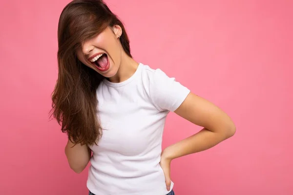 Retrato de mujer alegre positiva de moda en camiseta blanca casual para maqueta aislada sobre fondo rosa con espacio de copia —  Fotos de Stock