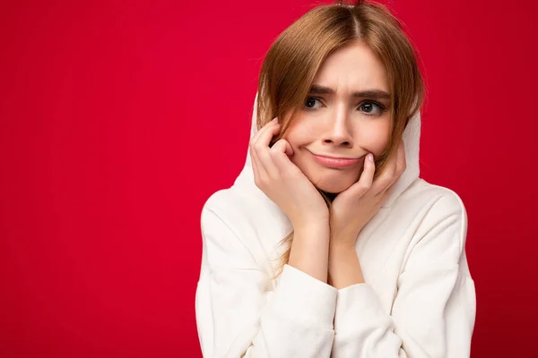 Joven mujer rubia oscura cansada y cansada con emociones sinceras aisladas en la pared de fondo con espacio para copiar usando sudadera con capucha blanca casual. Triste concepto — Foto de Stock