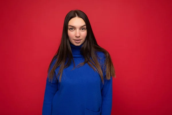 Junge sexy attarctive schöne brünette Frau mit aufrichtigen Emotionen isoliert auf Hintergrundwand mit Kopierraum trägt lässig trendigen blauen Pullover — Stockfoto