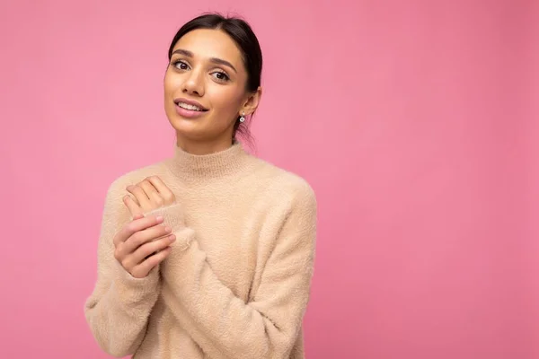 Vacker söt trevlig bedårande anbud ung brunett kvinna i casual beige jersey isolerad på rosa bakgrund med fritt utrymme och njuta — Stockfoto