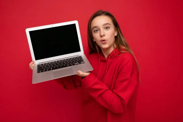 Zdjęcie pięknej młodej dziewczyny trzymającej laptopa komputerowego patrzącego na kamerę odizolowaną od kolorowego tła — Zdjęcie stockowe