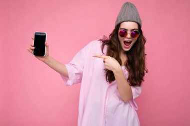 Güzel, gülümseyen genç bir kadının resmi. Günlük kıyafetlerini giymiş. Arka planda izole bir şekilde duruyor.