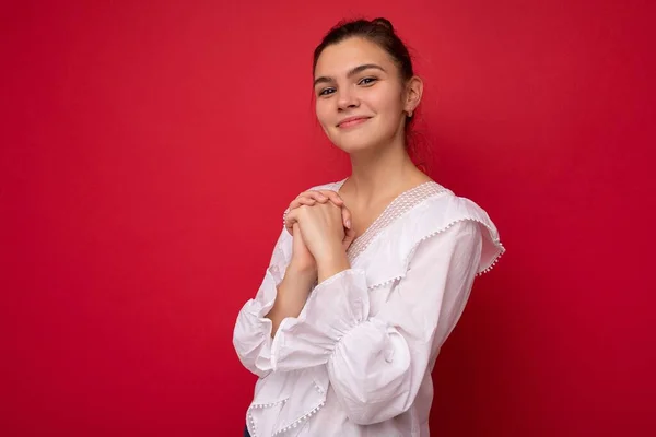 Jonge mooie Europese stijlvolle brunette vrouw draagt witte blouse geïsoleerd over rode achtergrond met positieve oprechte emoties. Eenvoudig en natuurlijk kijkend naar de camera. Vrije ruimte — Stockfoto