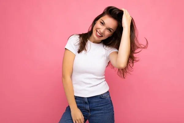 Портрет позитивной веселой модной женщины в повседневной футболке для макета изолирован на розовом фоне с копировальным пространством — стоковое фото