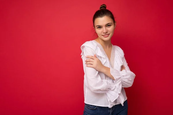 Fotoporträt der schönen glücklichen lustigen jungen brünetten Frau in stilvoller weißer Bluse. Sexy unbeschwerte weibliche Person posiert isoliert auf rotem Hintergrund. Positives Modell zeigt aufrichtige Emotionen — Stockfoto