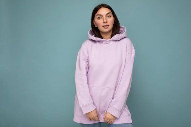 Arka plandaki duvarda izole edilmiş samimi duyguları olan güzel esmer bir kadın. Fotokopi alanı olan şık mor kapüşonlu bir kadın. Pozitif kavram
