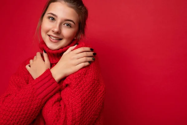 Κοντινή φωτογραφία της νεαρής όμορφης μελαχρινής γυναίκας με ειλικρινή συναισθήματα που απομονώνονται στον τοίχο του φόντου με χώρο αντιγραφής φορώντας μοντέρνο κόκκινο πουλόβερ. χαμόγελο και χαρούμενη έννοια — Φωτογραφία Αρχείου