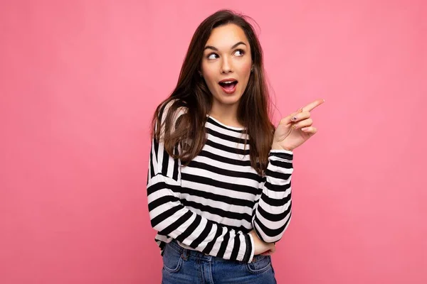 Retrato de bela fascinante emocional positivo alegre alegre promotor feminino apontando para o lado no espaço de cópia para publicidade vestindo roupa hipster isolado sobre a parede de fundo com vazio — Fotografia de Stock