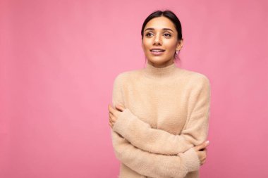 Güzel, sevimli, sevimli, tapılası, genç esmer kadın. Günlük bej formalı. Pembe arka planda izole edilmiş.