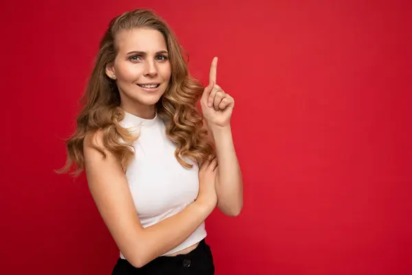 Φωτογραφία από ελκυστική έκπληκτος νεαρή γυναίκα δείχνοντας δάχτυλο επάνω στο copyspace παρουσιάζοντας διαφημίσεις promo με wow omg ειλικρινή συναισθήματα φορώντας καλή εμφάνιση στολή απομονώνονται σε φόντο με ελεύθερο χώρο — Φωτογραφία Αρχείου