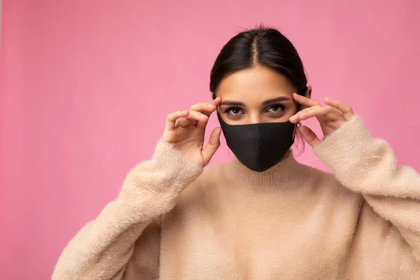 Bruneta žena na sobě antivirové ochranné masky, aby se zabránilo ostatním z corona COVID-19 a SARS cov 2 infekce izolované na růžovém pozadí — Stock fotografie