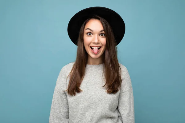 Portret van schattig aantrekkelijk mooi jong gelukkig positief brunette vrouw dragen casual gestreepte trui geïsoleerd over kleurrijke achtergrond met kopieerruimte en tonen tong — Stockfoto