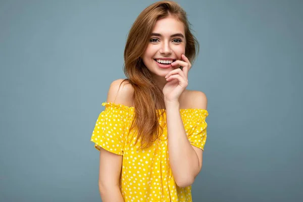 Jovem sorrindo bela mulher loira escura com emoções sinceras isoladas na parede de fundo com espaço de cópia vestindo elegante vestido amarelo de verão. Conceito positivo — Fotografia de Stock