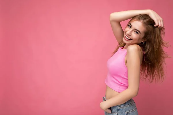 Fotografie krásné pozitivní usměvavé dospělé ženy na sobě stylové oblečení stojící izolované na barevném pozadí s kopírovacím prostorem při pohledu do kamery — Stock fotografie