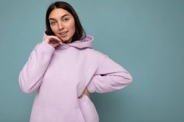 Çekici, mutlu, duygusal bir kadının arka plandaki duvarda izole edilmiş, rahat kıyafetler giyerek zehirlenmesinin fotoğrafı.