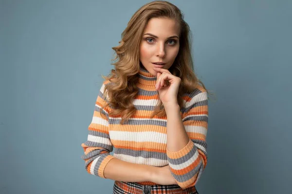 Молода чарівна сексуальна щаслива блондинка в повсякденній смугастій пуловері ізольована на синьому фоні з вільним простором — стокове фото