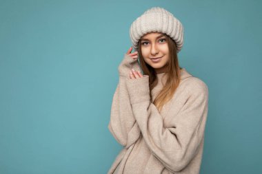 Güzel, pozitif, mutlu, esmer, sarışın bir kadın. Renkli arka plan duvarından izole edilmiş, günlük, şık kıyafetler giymiş. Kameraya bakarken samimi duygular hissediyor.