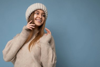 Güzel, pozitif, mutlu, esmer, sarışın bir kadın renkli arka plan duvarından izole edilmiş, günlük tarz kıyafetler giymiş, samimi duygular besliyor.