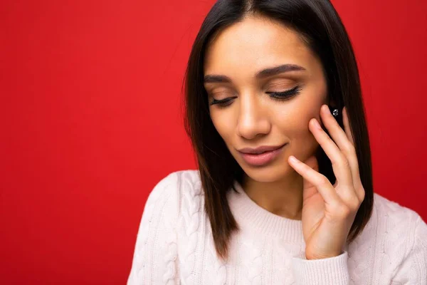 Closeup retrato de fascinante bonito agradável adorável jovem morena em luz casual camisola de malha isolado no fundo vermelho com espaço livre e desfrutando — Fotografia de Stock