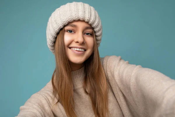 Foto de primer plano de una hermosa mujer rubia oscura sonriente y feliz de pie aislada sobre una colorida pared de fondo usando ropa de moda cotidiana mirando a la cámara mostrando emociones faciales —  Fotos de Stock