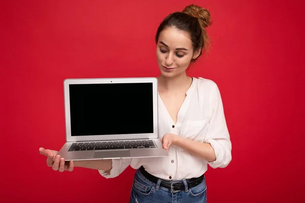 Primer plano retrato de hermosa mujer joven sosteniendo ordenador portátil mirando netbook divertirse usando ropa elegante casual aislado sobre fondo de pared —  Fotos de Stock